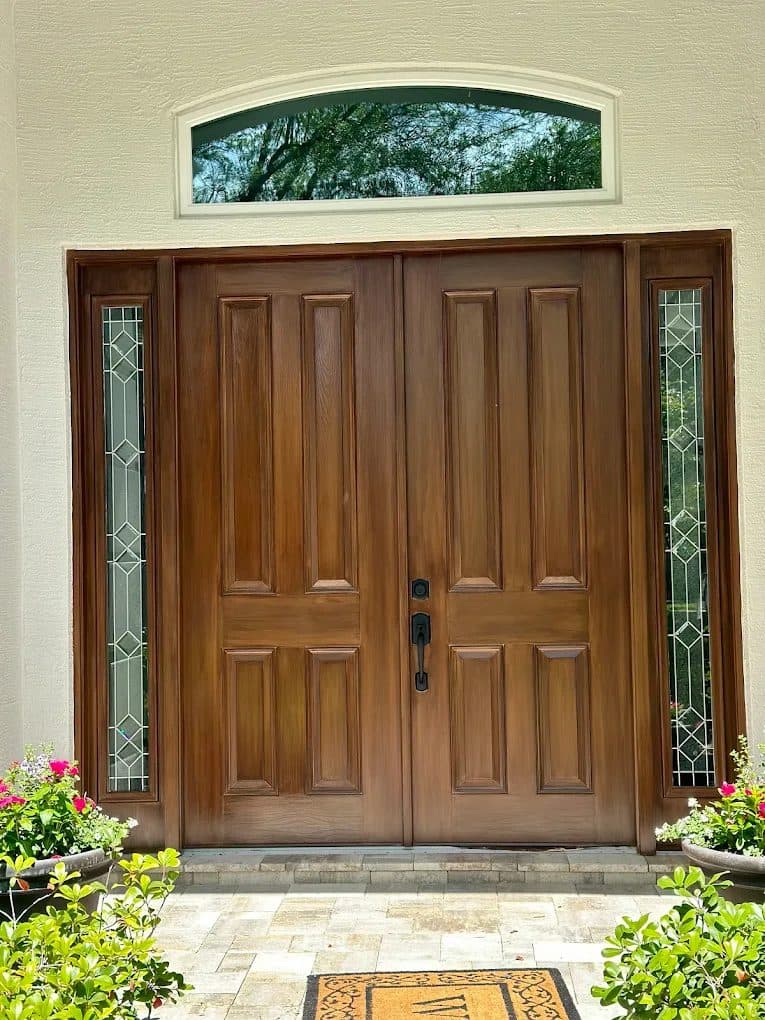Double front doors refinished in a rich wood-grain finish